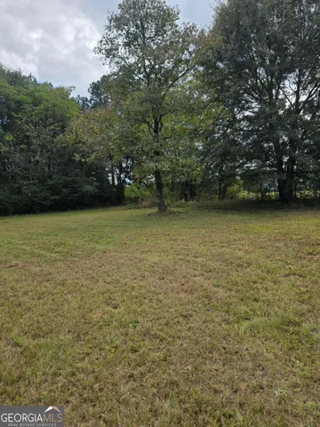 a view of a field with an trees in the background