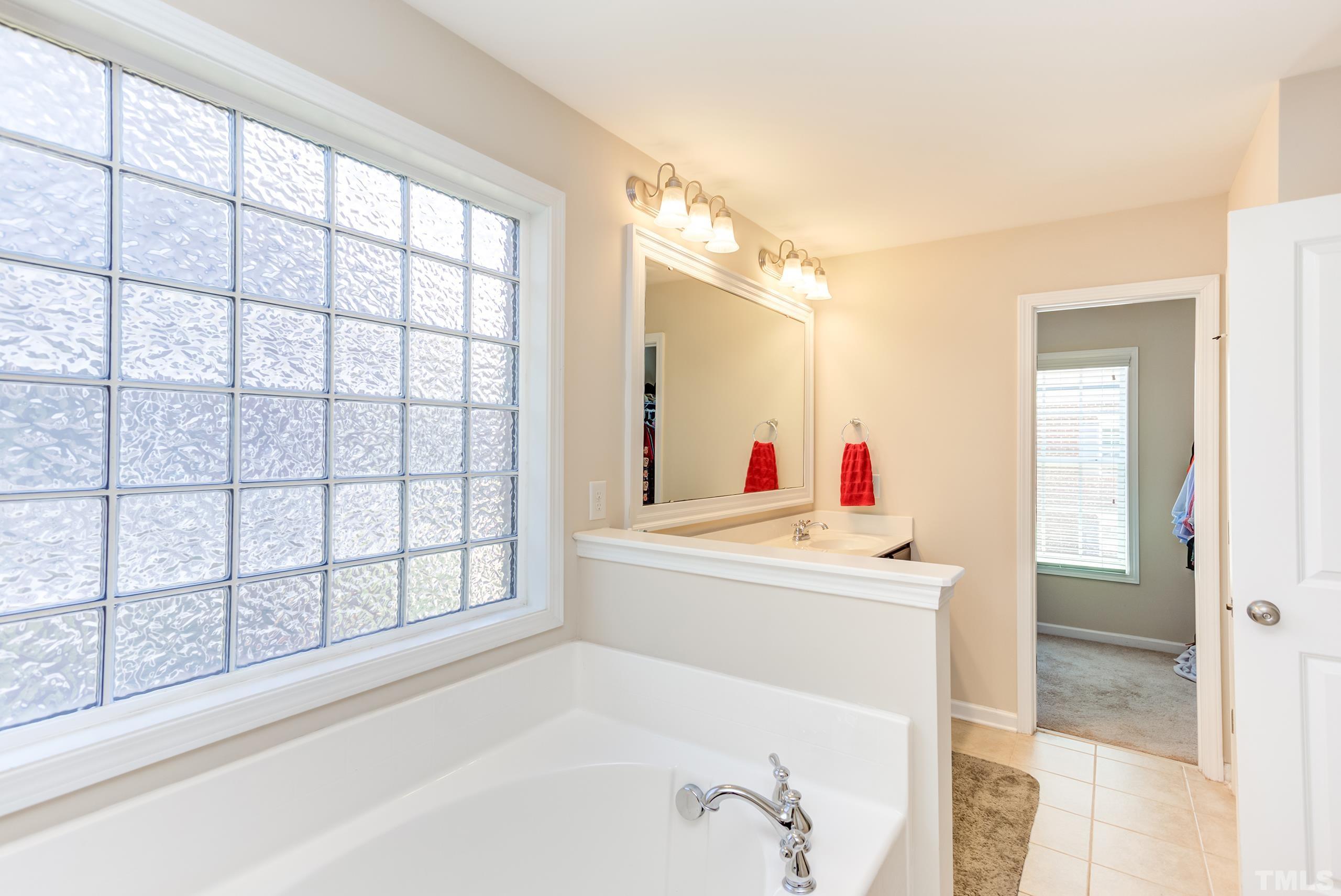1313 Still Monument Way Raleigh, NC 27603 - Photo 20 of 35 a en suite bathroom with a sink and a large mirror