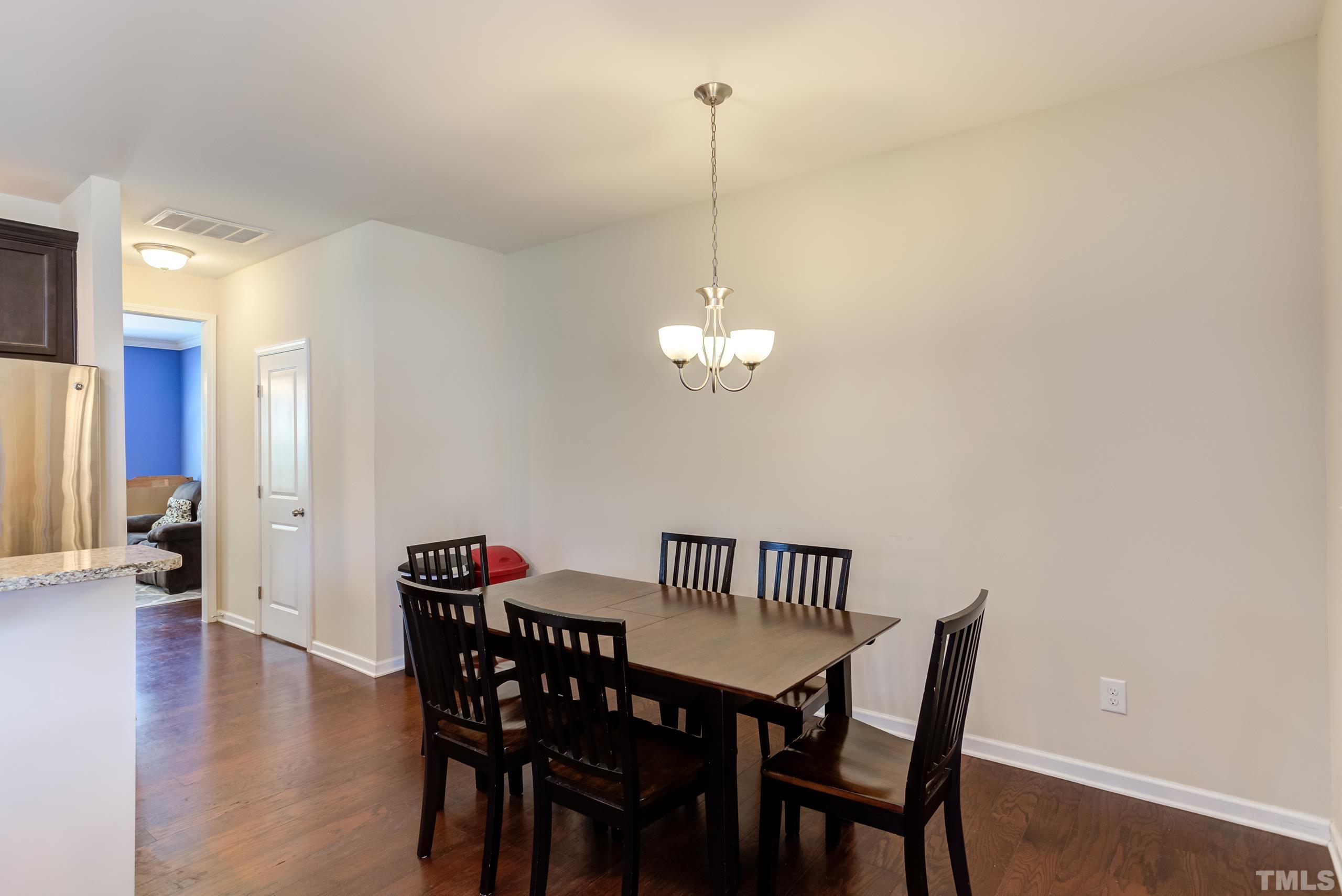 1313 Still Monument Way Raleigh, NC 27603 - Photo 8 of 35 a view of a dining room with furniture wooden floor and chandelier