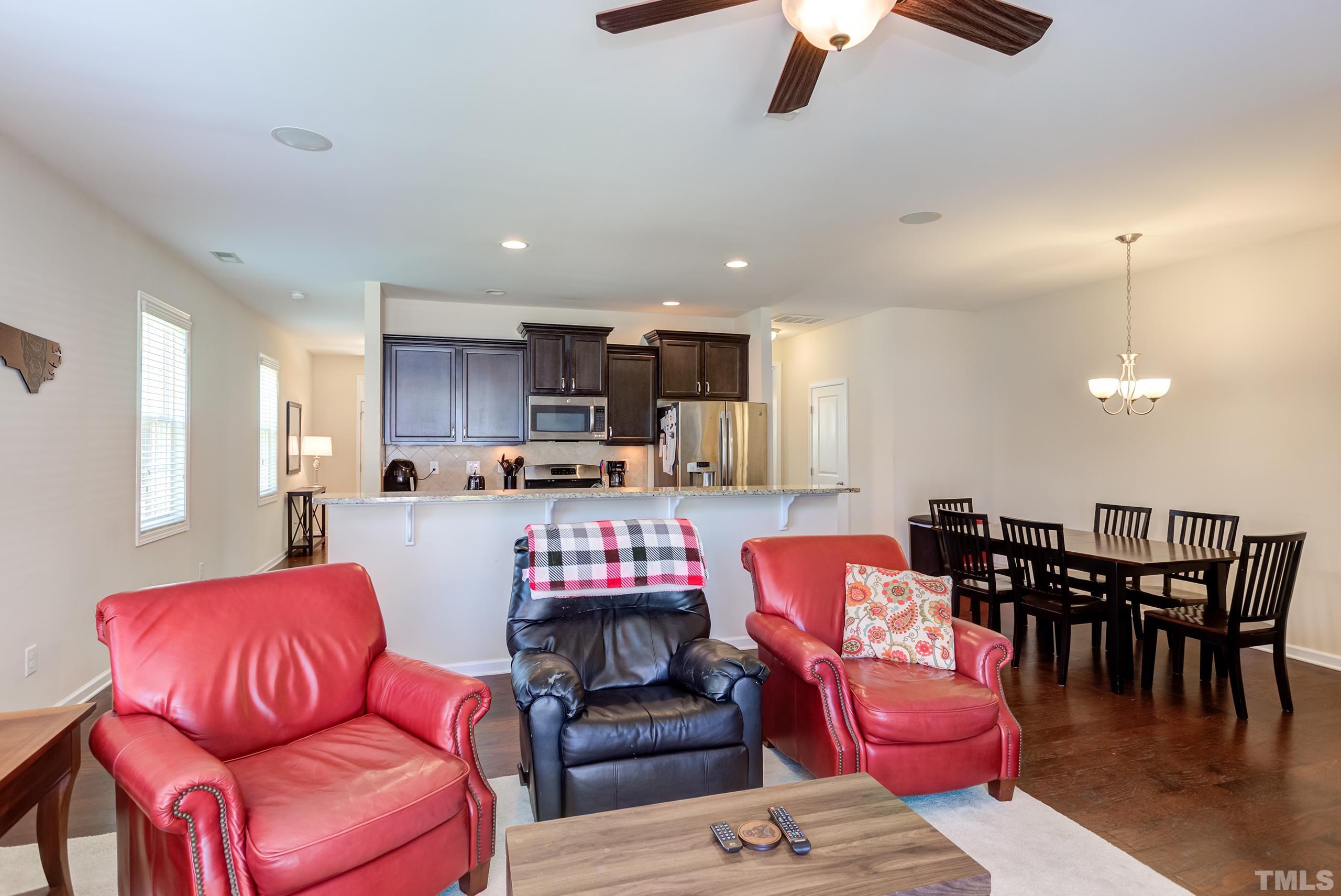1313 Still Monument Way Raleigh, NC 27603 - Photo 9 of 35 a living room with furniture kitchen view and a chandelier