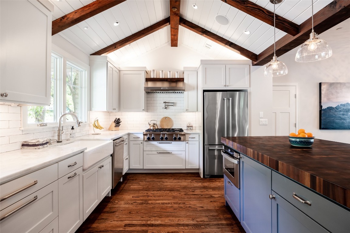 a kitchen with stainless steel appliances granite countertop a sink stove and refrigerator