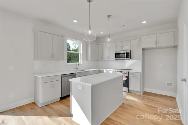 a kitchen with stainless steel appliances kitchen island a refrigerator sink and microwave