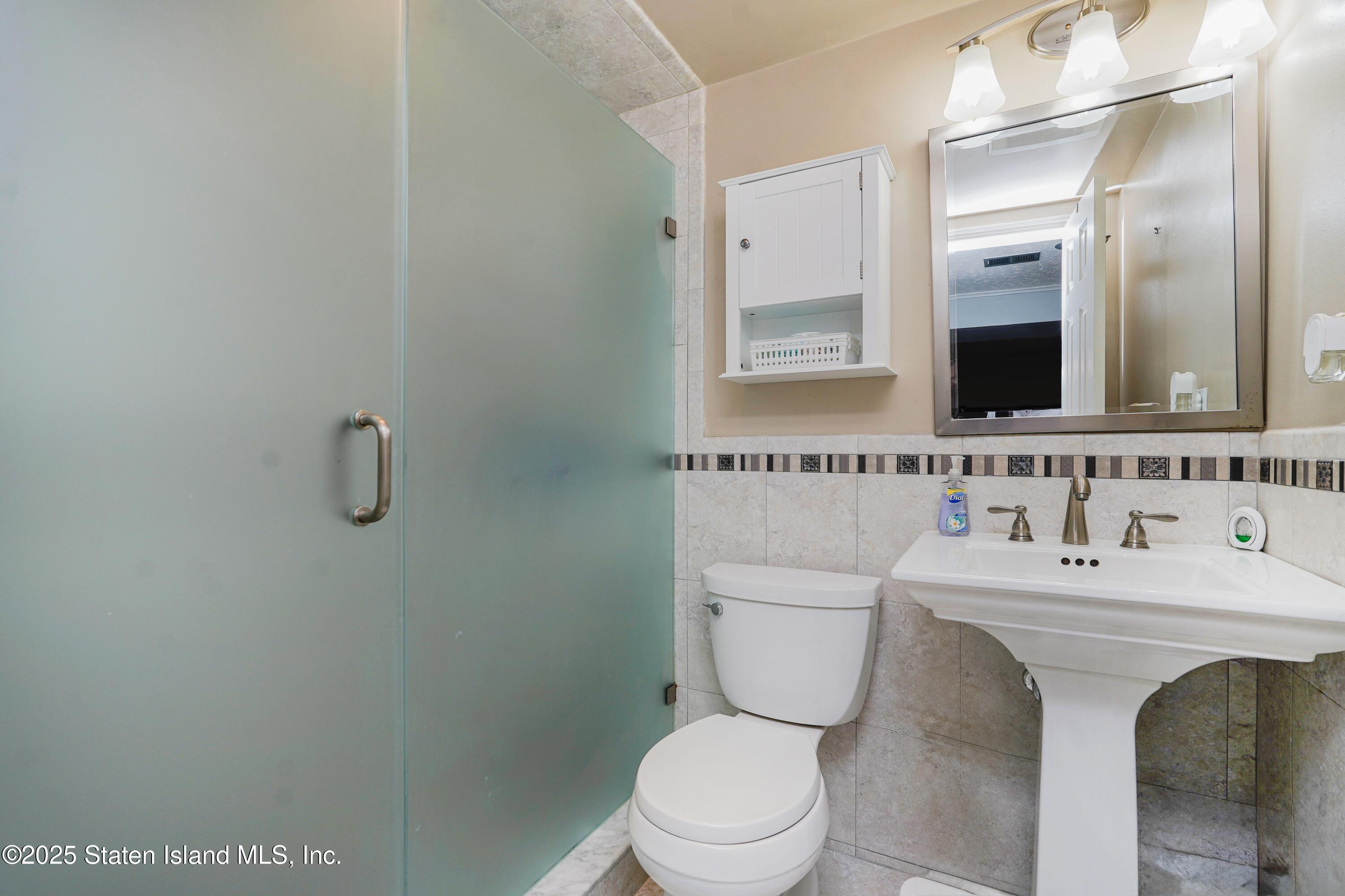 10 Draper Place Staten Island, NY 10314 - Photo 13 of 20 a bathroom with a toilet a sink and mirror