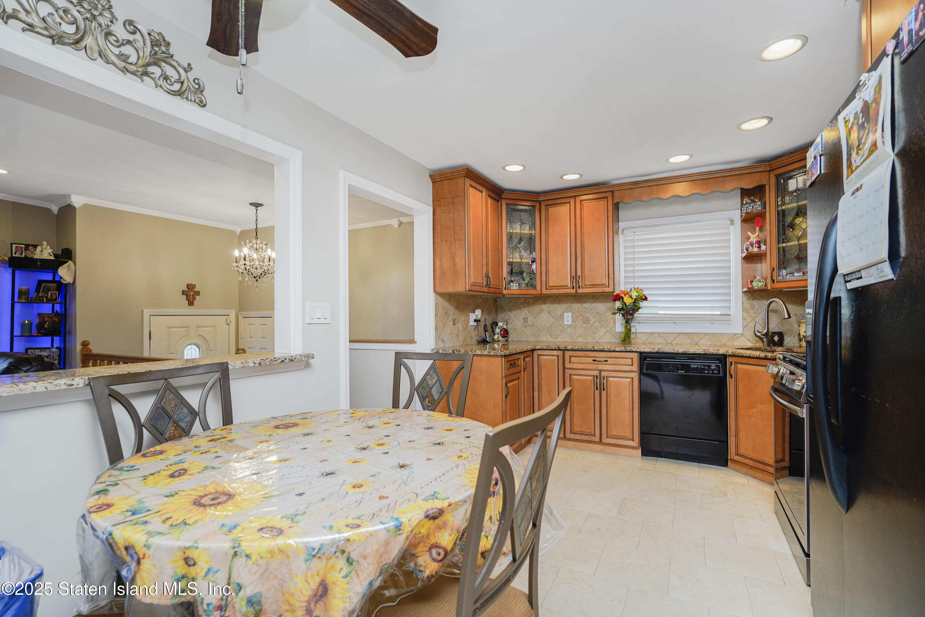 10 Draper Place Staten Island, NY 10314 - Photo 5 of 20 a kitchen with stainless steel appliances kitchen island granite countertop a dining table chairs sink and wooden floor