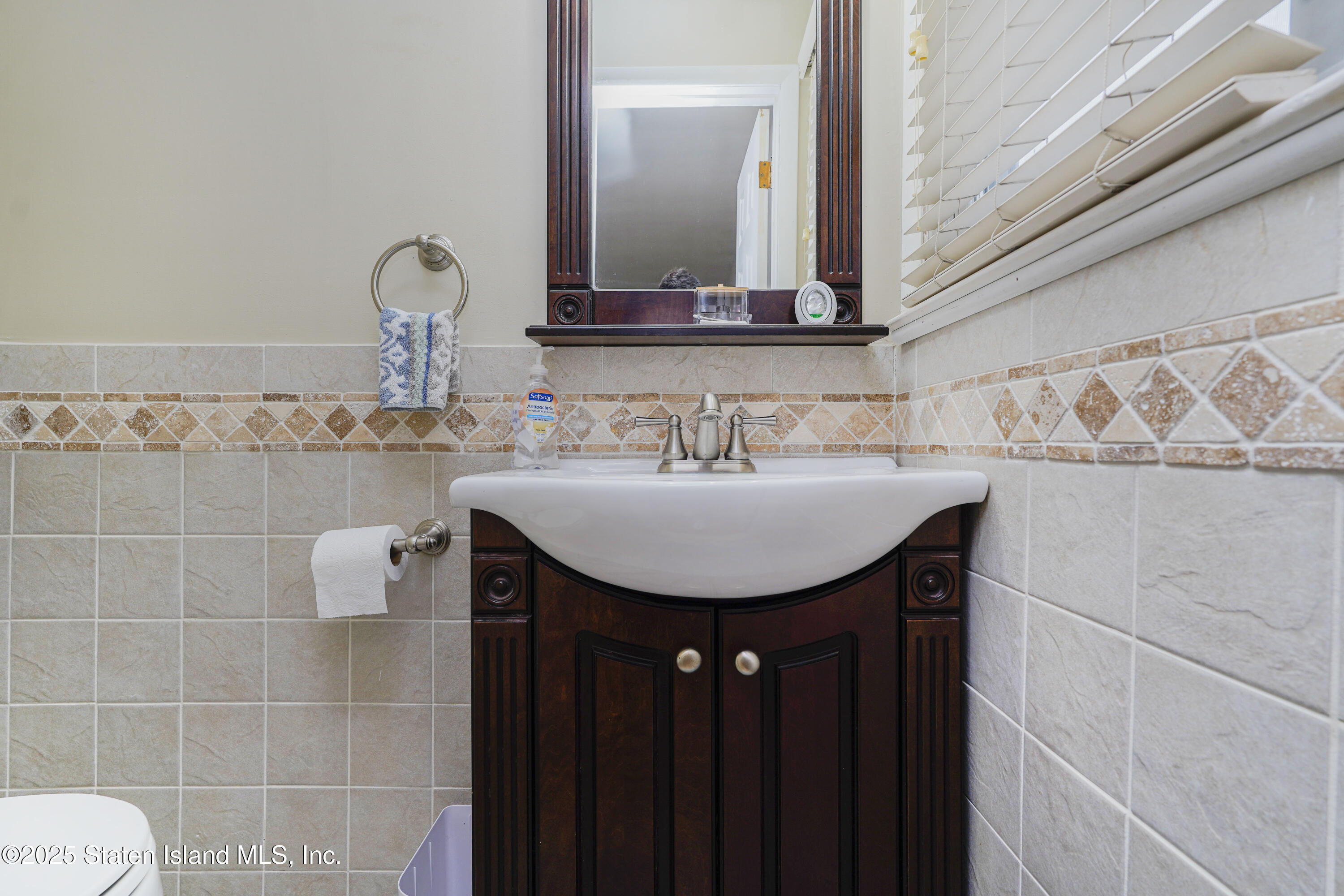 10 Draper Place Staten Island, NY 10314 - Photo 10 of 20 a bathroom with a sink a mirror and vanity