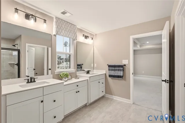 a spacious bathroom with double sink and a mirror
