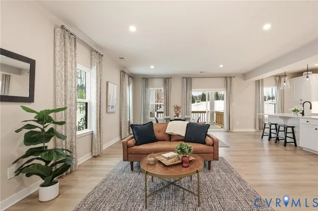 a living room with furniture potted plant and wooden floor
