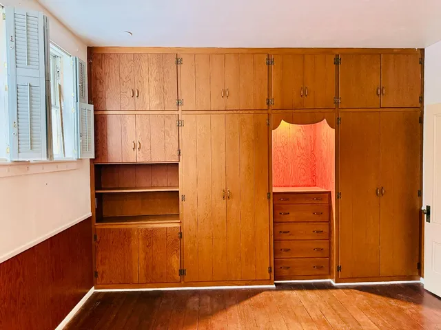 a house that is sitting in the grass with large trees