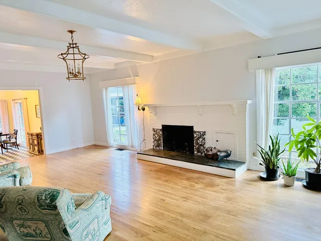 a view of a livingroom with furniture a flat screen tv and wooden floor