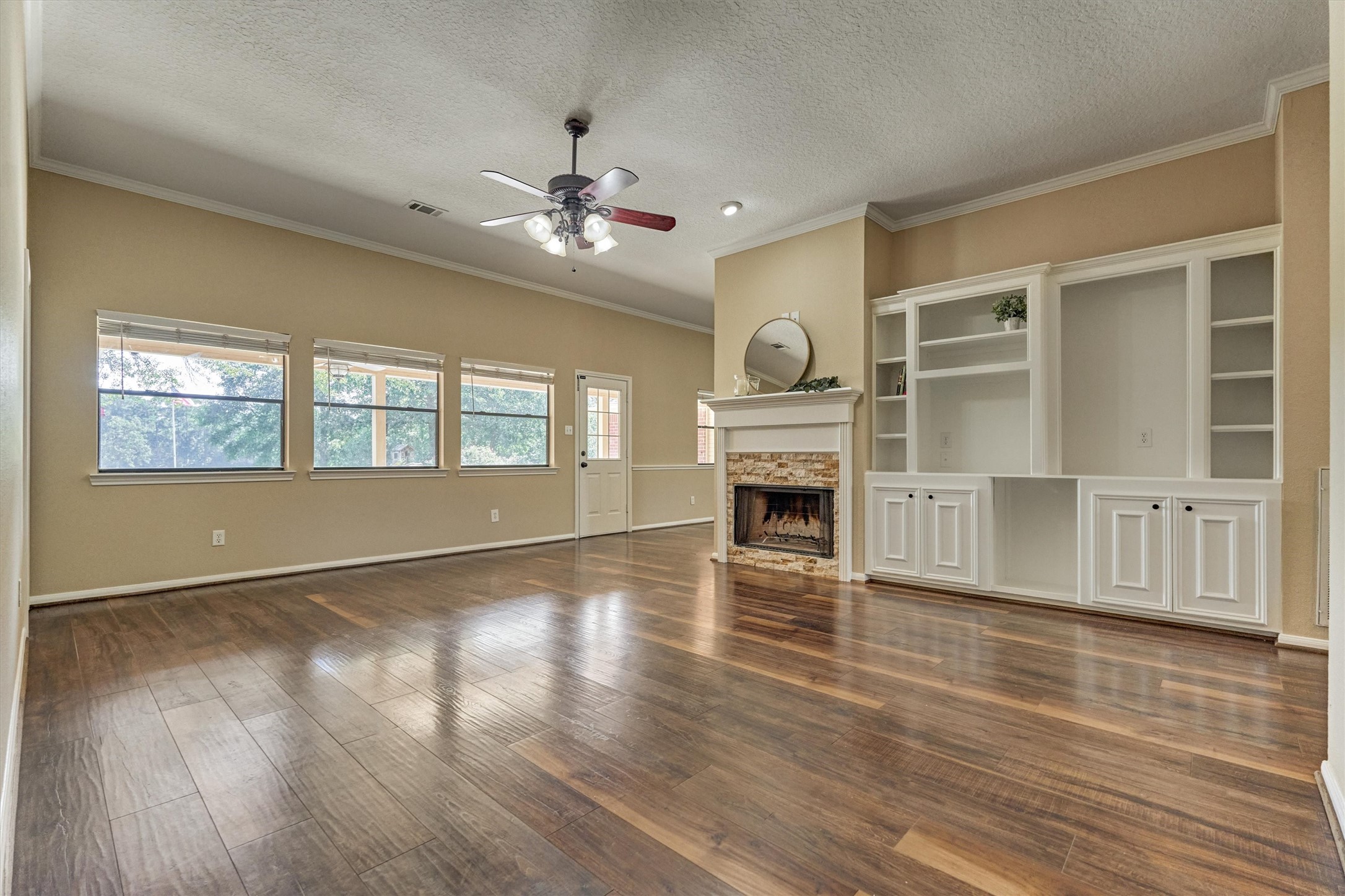 16024 Rabon Chapel Road Montgomery, TX 77316 - Photo 15 of 43 A large living room features a cozy gas log fireplace, built-in cabinetry and windows overlooking the backyard.