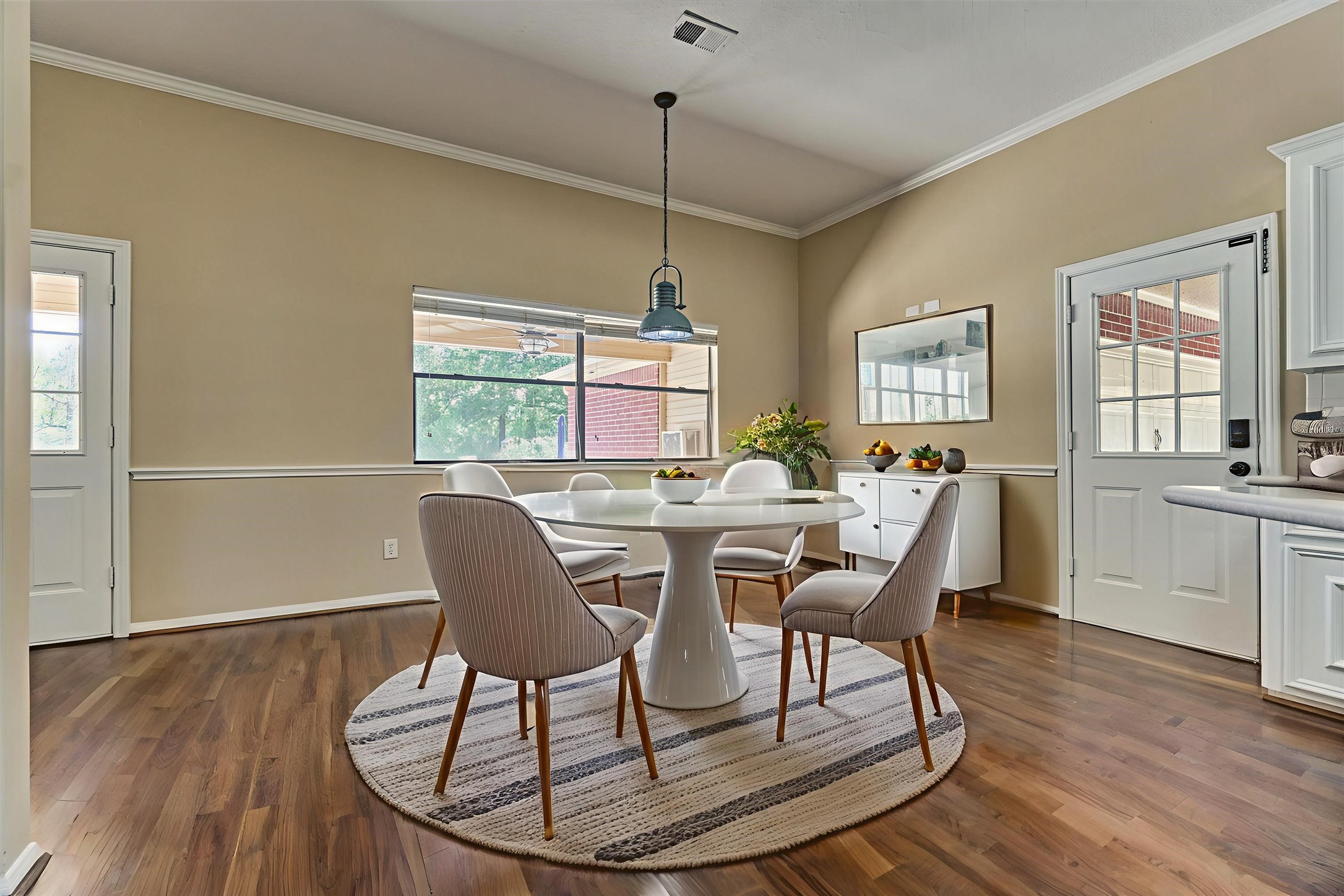 16024 Rabon Chapel Road Montgomery, TX 77316 - Photo 22 of 43 The breakfast area is bright with natural light. The door to the right leads to the carport area for easy access with unloading groceries. A charming chair rail and crown molding continue into this space for a custom touch.