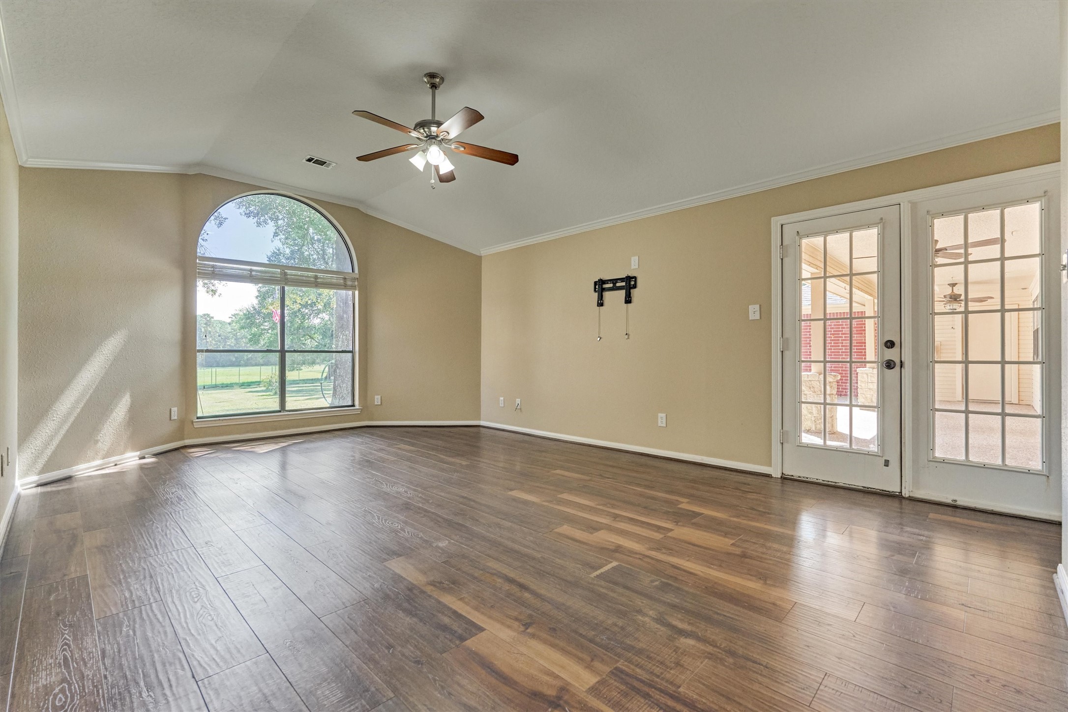 16024 Rabon Chapel Road Montgomery, TX 77316 - Photo 24 of 43 A large window with arched transom overlooks the backyard and lets in beautiful natural light. Double doors lead to the back porch for easy access to relax and enjoy the property views.