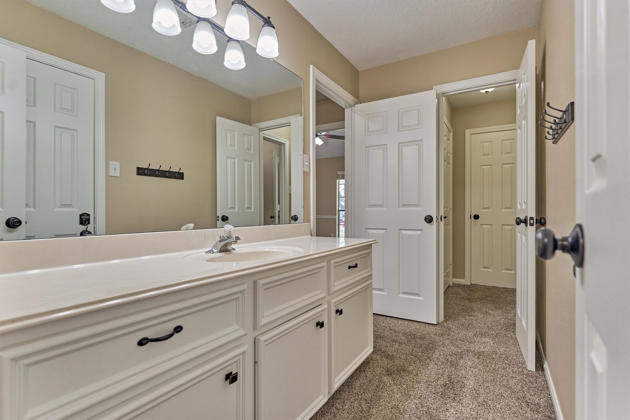 16024 Rabon Chapel Road Montgomery, TX 77316 - Photo 29 of 43 Sink area in the jack and jill bath has plenty of counter and storage space. Doors beyond lead to the hallway and tub/shower area.