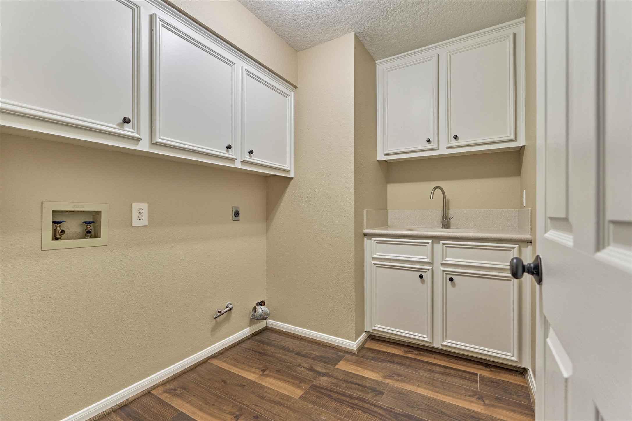 16024 Rabon Chapel Road Montgomery, TX 77316 - Photo 32 of 43 The laundry room offers a sink, cabinet storage, and built-in ironing board. Gas and electric dryer connections