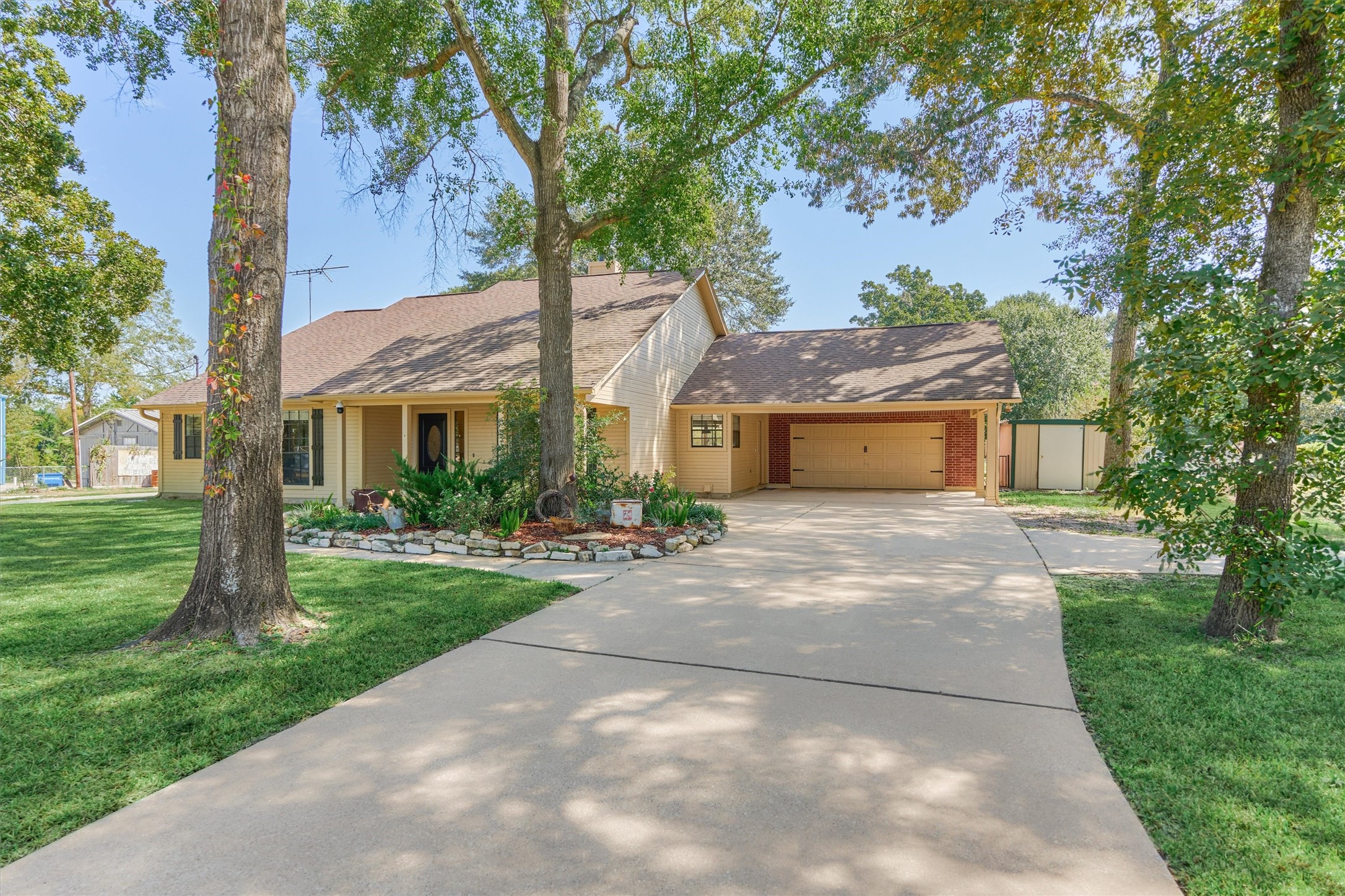 16024 Rabon Chapel Road Montgomery, TX 77316 - Photo 8 of 43 Pull into the property to a nicely landscaped front yard and large mature shade trees. The carport outside the garage provides extra covered parking.