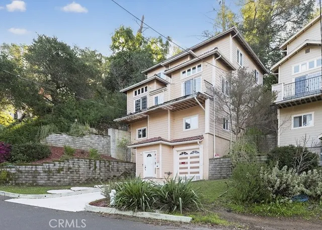 a view of a white building among the street with palm trees