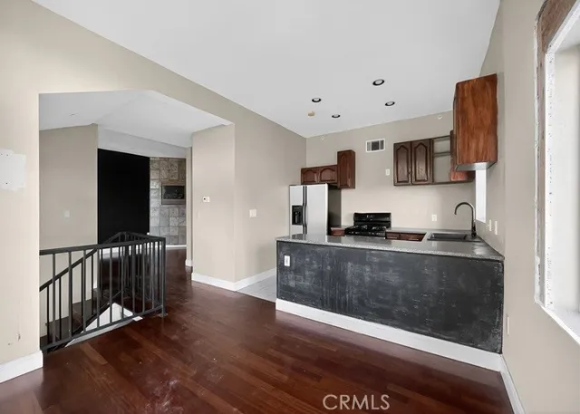 a kitchen with stainless steel appliances granite countertop a stove a sink and a refrigerator