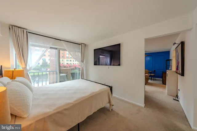 a bedroom with a bed and a large window