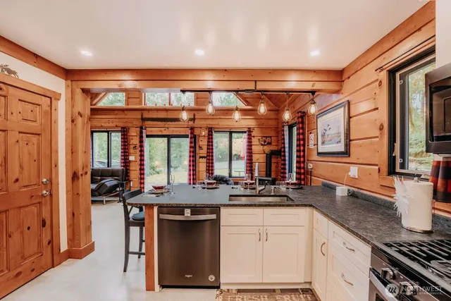 a kitchen with stainless steel appliances granite countertop a sink stove and cabinets