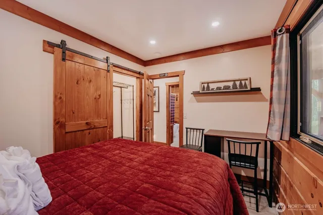 a bedroom with a bed and a large window