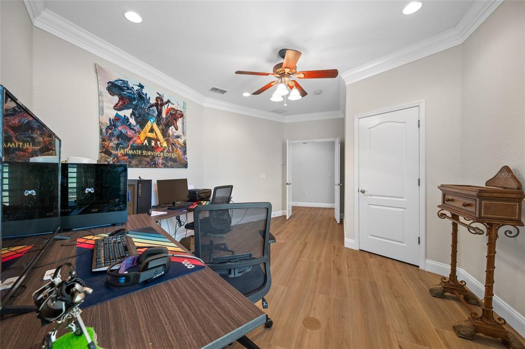 11939 Pasco Trails Boulevard Spring Hill, FL 34610 - Photo 12 of 61 a view of a livingroom with furniture a flat screen tv and wooden floor