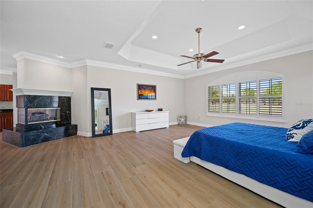 11939 Pasco Trails Boulevard Spring Hill, FL 34610 - Photo 15 of 61 a bedroom with a bed and a chandelier