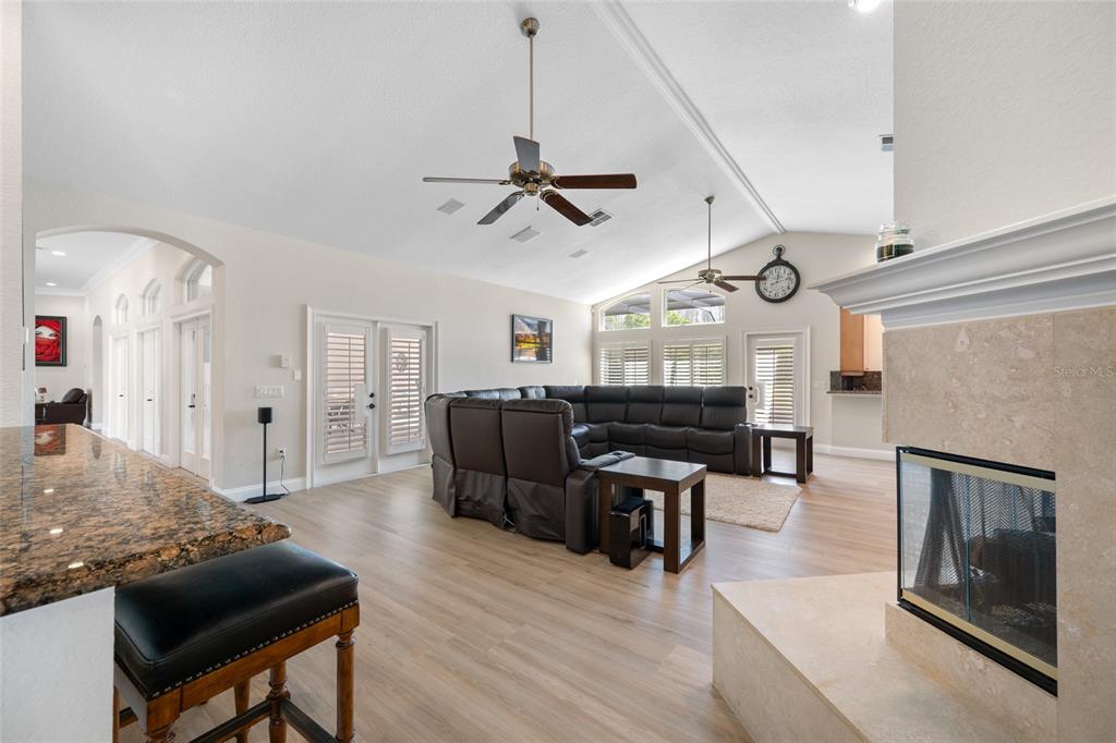 11939 Pasco Trails Boulevard Spring Hill, FL 34610 - Photo 27 of 61 a living room with furniture a fireplace and wooden floor