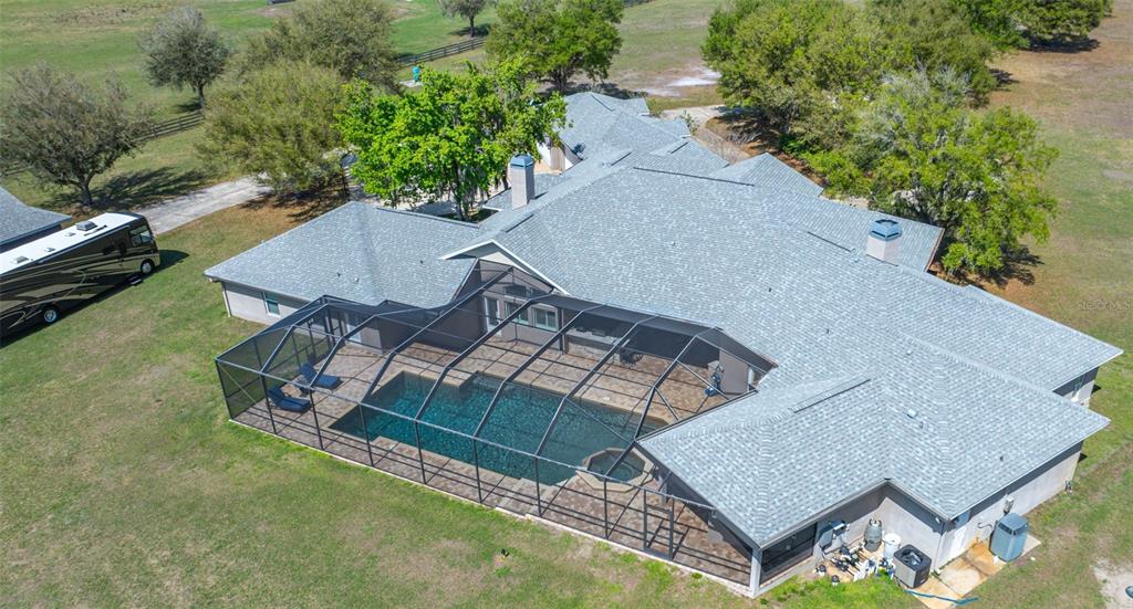 11939 Pasco Trails Boulevard Spring Hill, FL 34610 - Photo 3 of 61 an aerial view of a house with a yard and mountain