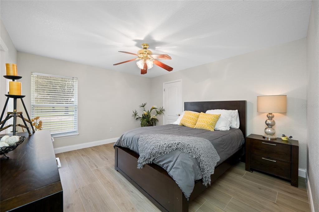 11939 Pasco Trails Boulevard Spring Hill, FL 34610 - Photo 42 of 61 a bedroom with a bed and wooden floor