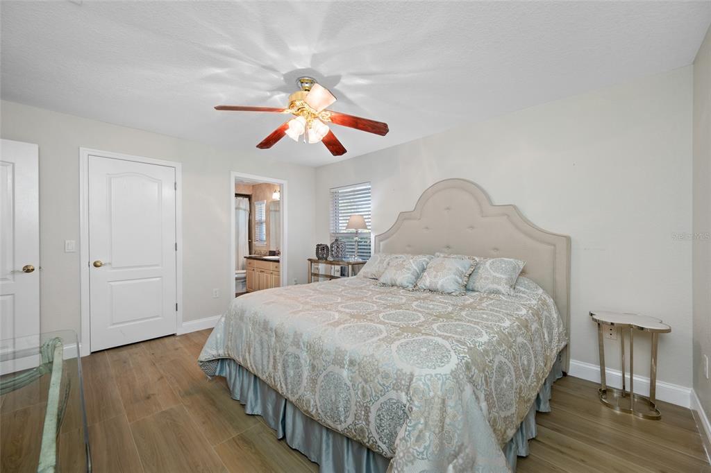 11939 Pasco Trails Boulevard Spring Hill, FL 34610 - Photo 44 of 61 a bedroom with a bed and wooden floor