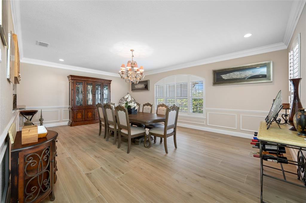 11939 Pasco Trails Boulevard Spring Hill, FL 34610 - Photo 47 of 61 a view of a dining room with furniture and wooden floor