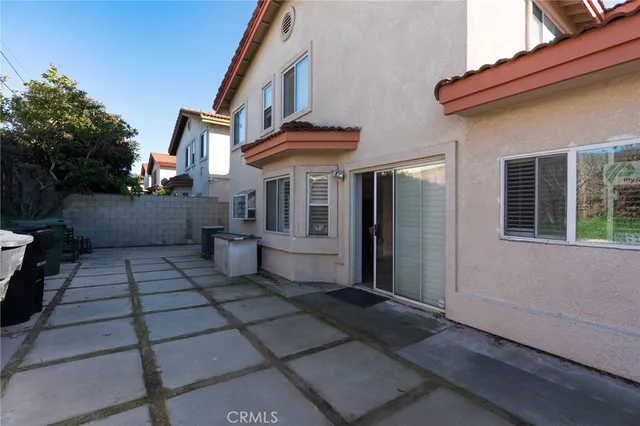 a view of a white house with many windows next to a yard