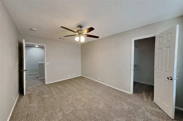 an empty room with fan and entrance