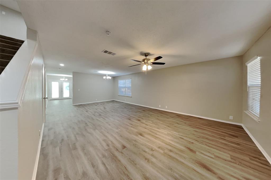 1320 Stetson Trail Saginaw, TX 76131 - Photo 2 of 19 a view of an empty room with wooden floor and a window