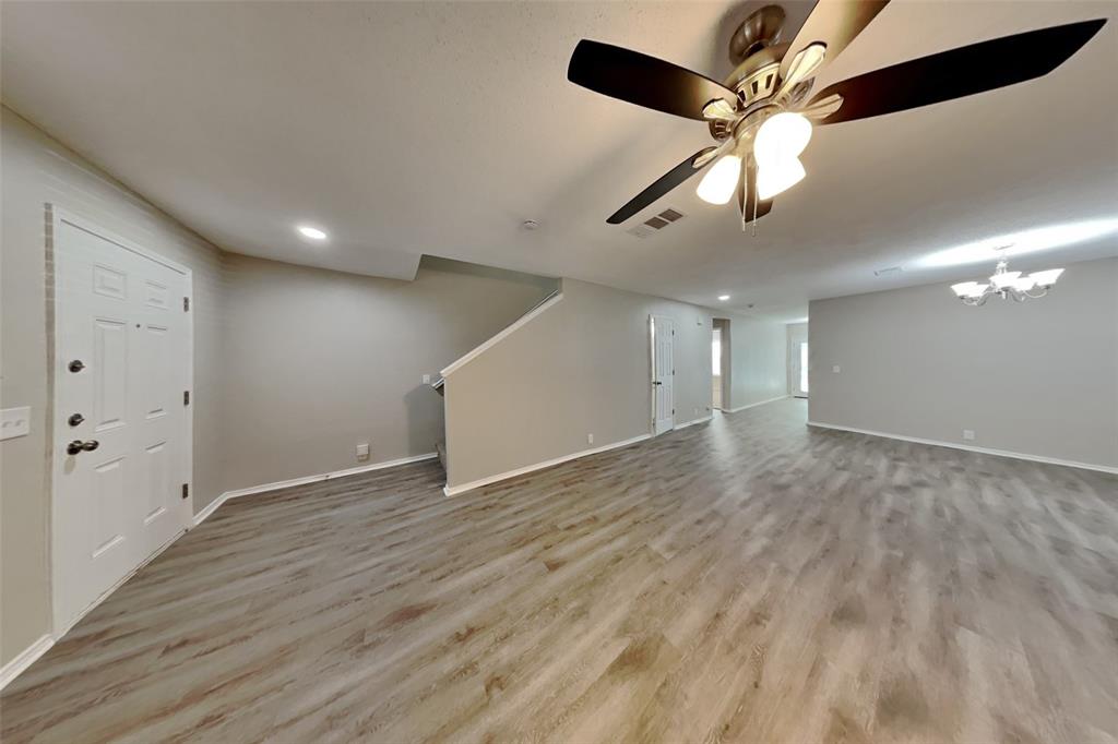 1320 Stetson Trail Saginaw, TX 76131 - Photo 3 of 19 a view of an empty room with wooden floor and a ceiling fan