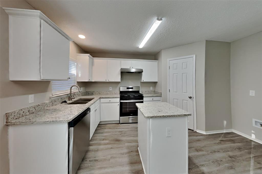 1320 Stetson Trail Saginaw, TX 76131 - Photo 4 of 19 a kitchen with a stove top oven a sink a counter space and cabinets