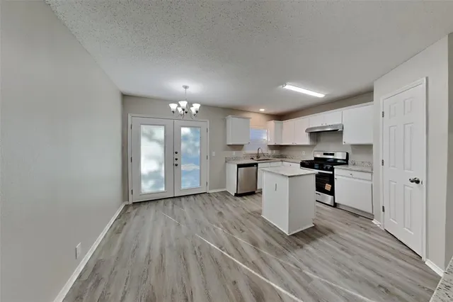 a kitchen with a refrigerator and white cabinets