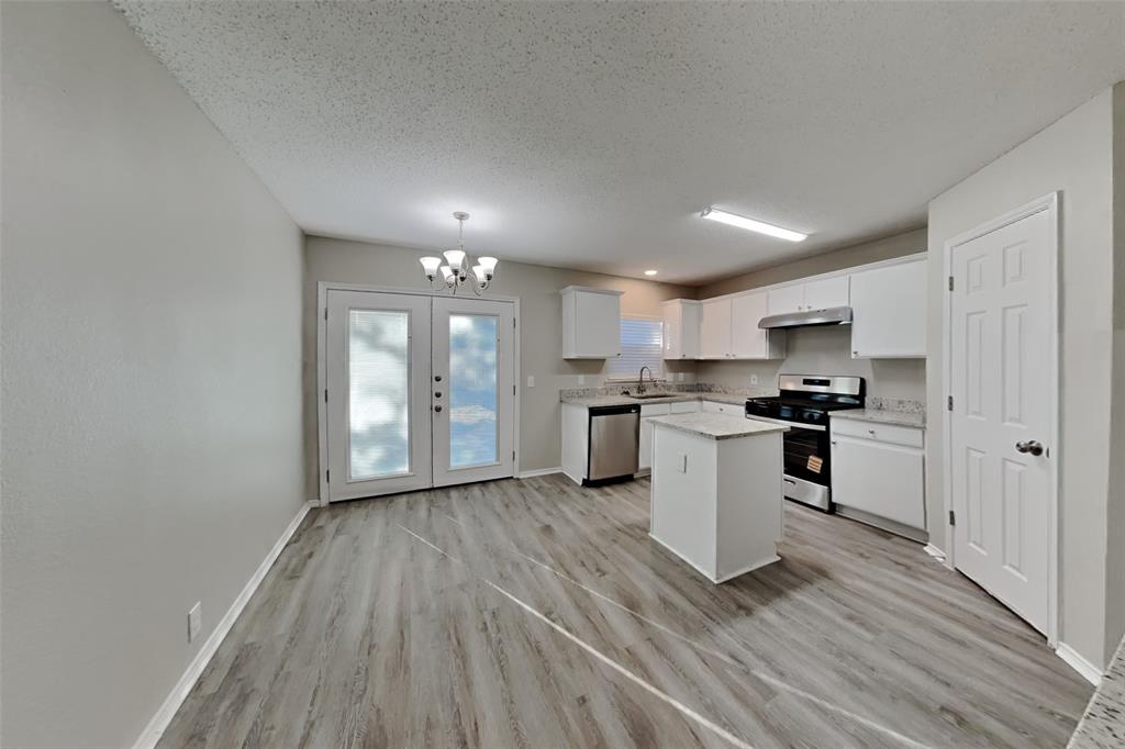 1320 Stetson Trail Saginaw, TX 76131 - Photo 5 of 19 a kitchen with a refrigerator and white cabinets