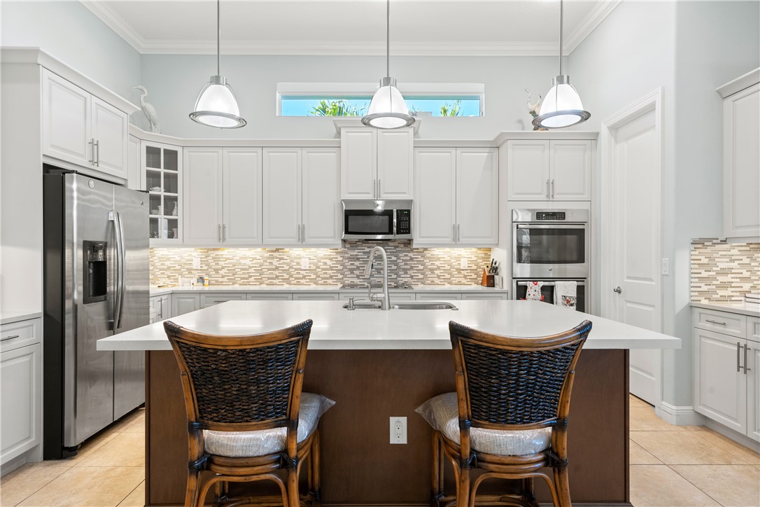 a kitchen with stainless steel appliances granite countertop a kitchen island a stove a table and chairs