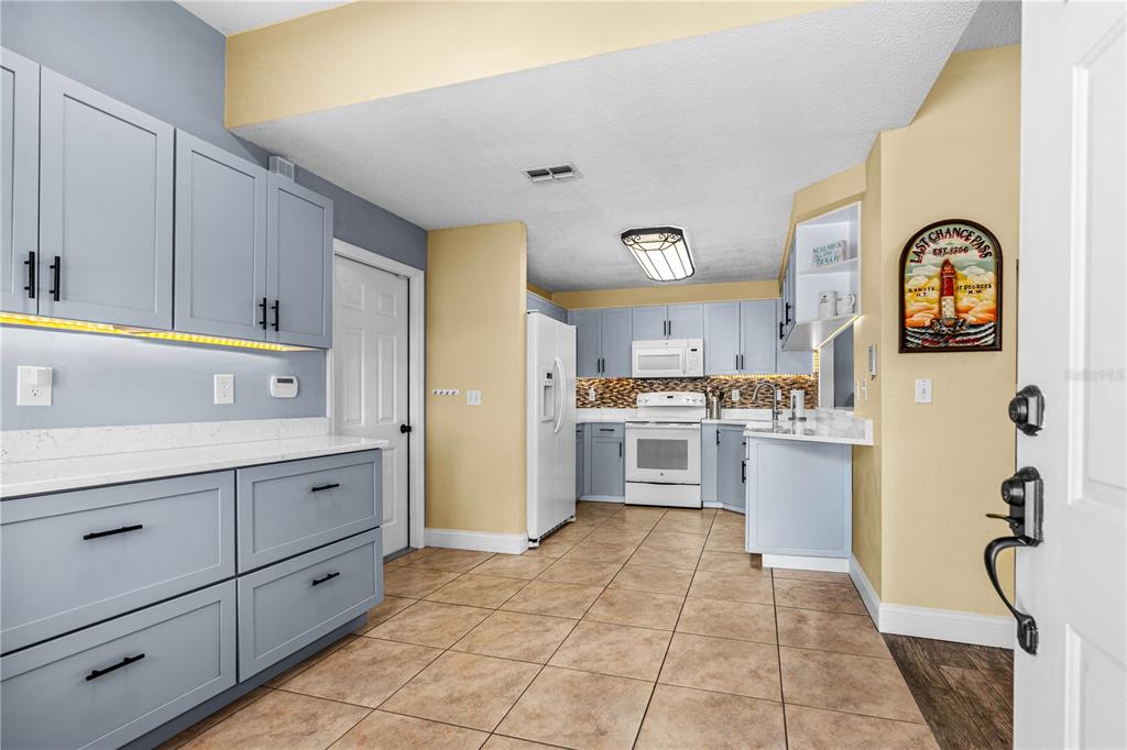 124 Rose Bank Road Daytona Beach, FL 32114 - Photo 12 of 43 a kitchen with a refrigerator a stove top oven and a sink