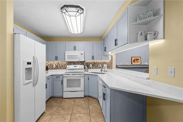 a kitchen with a sink a stove top oven and cabinets