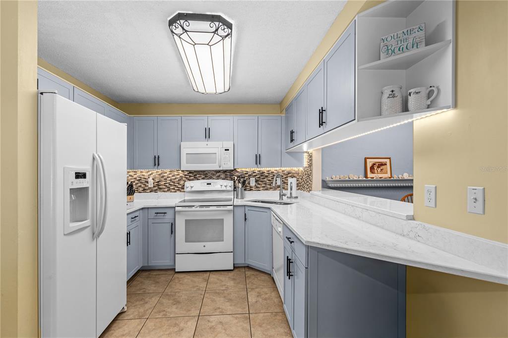 124 Rose Bank Road Daytona Beach, FL 32114 - Photo 13 of 43 a kitchen with a sink a stove top oven and cabinets