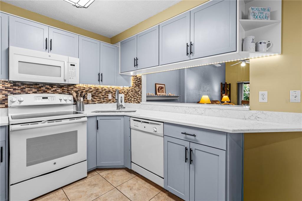 124 Rose Bank Road Daytona Beach, FL 32114 - Photo 14 of 43 a kitchen with stainless steel appliances granite countertop a sink stove and cabinets