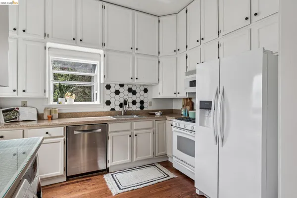 a kitchen with granite countertop white cabinets and window