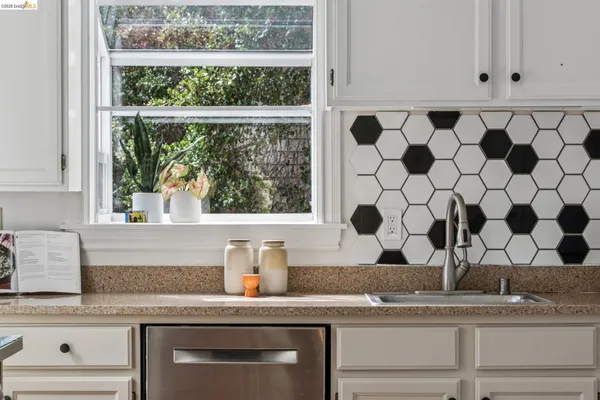 a kitchen with stainless steel appliances white cabinets and wooden floor