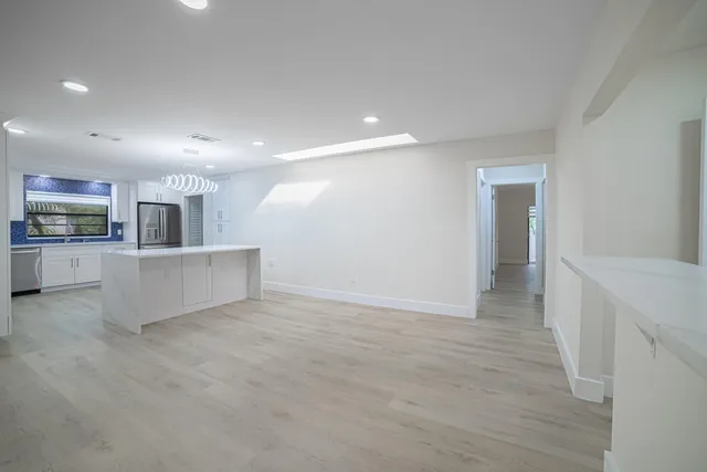 a large kitchen with cabinets wooden floor and stainless steel appliances