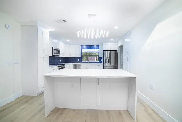 a spacious bathroom with a granite countertop sink a mirror and a vanity