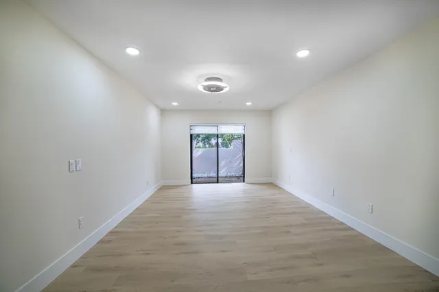 an empty room with wooden floor and closet area