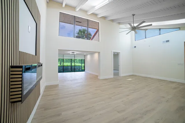 a view of a hallway with wooden floor and windows