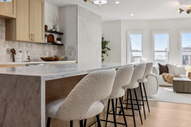 a living room with furniture and a view of kitchen